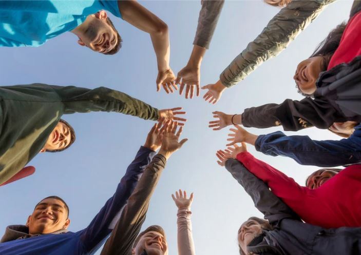 Students putting their hands together for a team high five